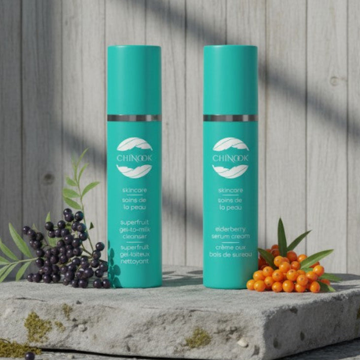 Two turquoise skincare bottles with a brand logo on a stone surface with berries and leaves.